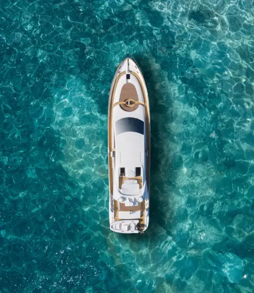 A huge white super Mega yacht on blue water in Italy. White sport yacht near the coast on the sea aerial view. Superyacht on clear water near the rocks, top view. A huge white super Mega yacht on blue water in Italy. White sport yacht near the coast on the sea aerial view. Superyacht on clear water near the rocks, top view.
